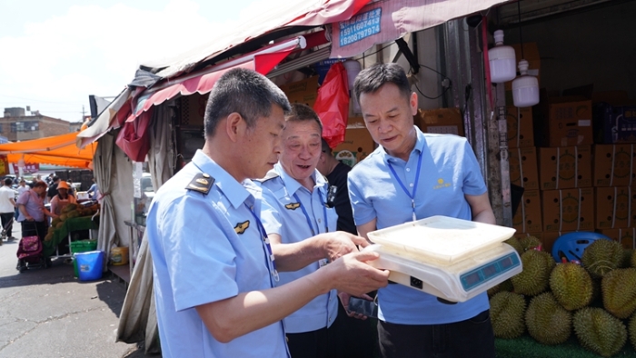 执法人员检查金马正昌水果批发市场商户计量器具